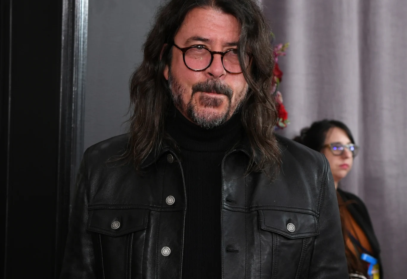 Dave Grohl przyznał się do romansu Dave Grohl ubrany w czarny golf i skórzaną kurtkę. Patrzy w kamerę z neutralnym wyrazem twarzy