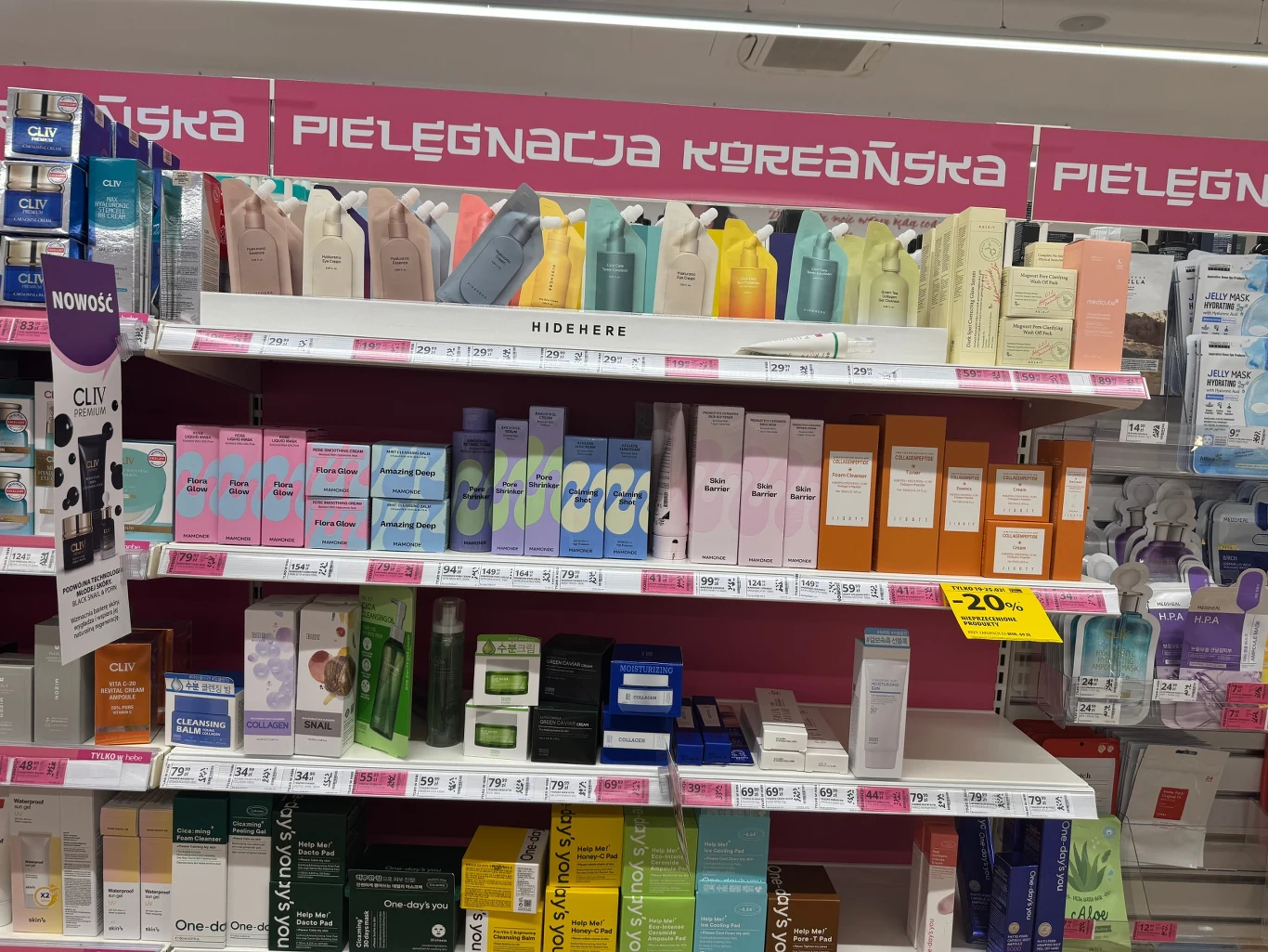 półki drogerii wypełnione koreańskimi kosmetykami do pielęgnacji skóry ułożonymi według kategorii, z kolorowymi opakowaniami kremów, masek i toników, podkreślone dużym różowym napisem 'pielęgnacja koreańska'