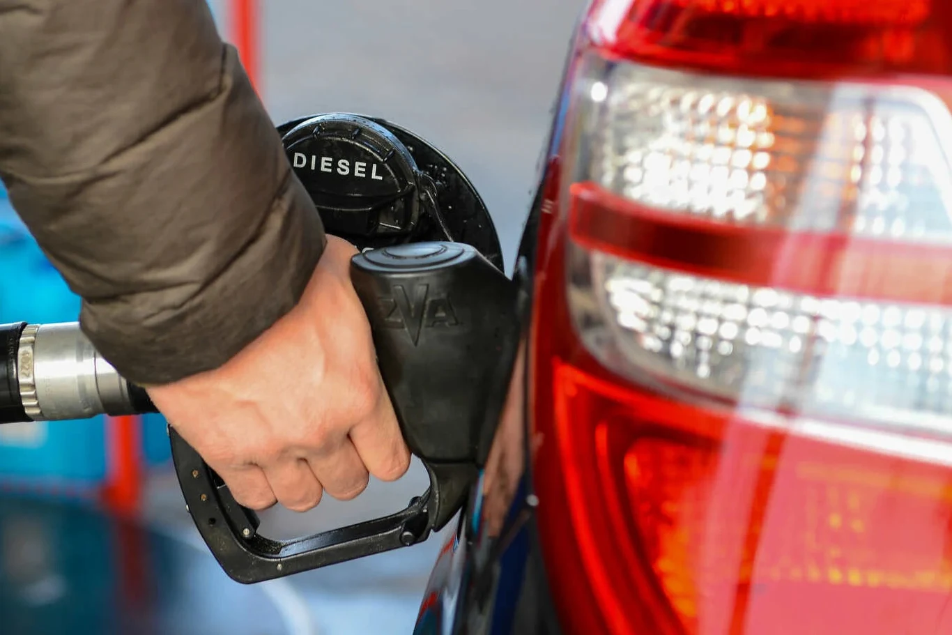 Ceny diesla od 23 marca przekroczą na stacjach 9 zł. To efekt nagłej podwyżki cen hurtowych przez Orlen Ręka trzymająca czarny dystrybutor 'DIESEL' podczas tankowania srebrnego auta na stacji paliw.