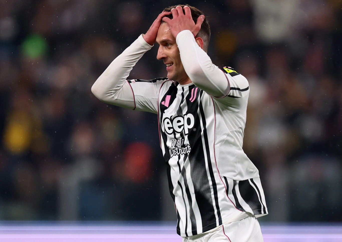 Arkadiusz Milik w biało-czarnej koszulce Juventusu z rękami na głowie podczas meczu z Sassuolo