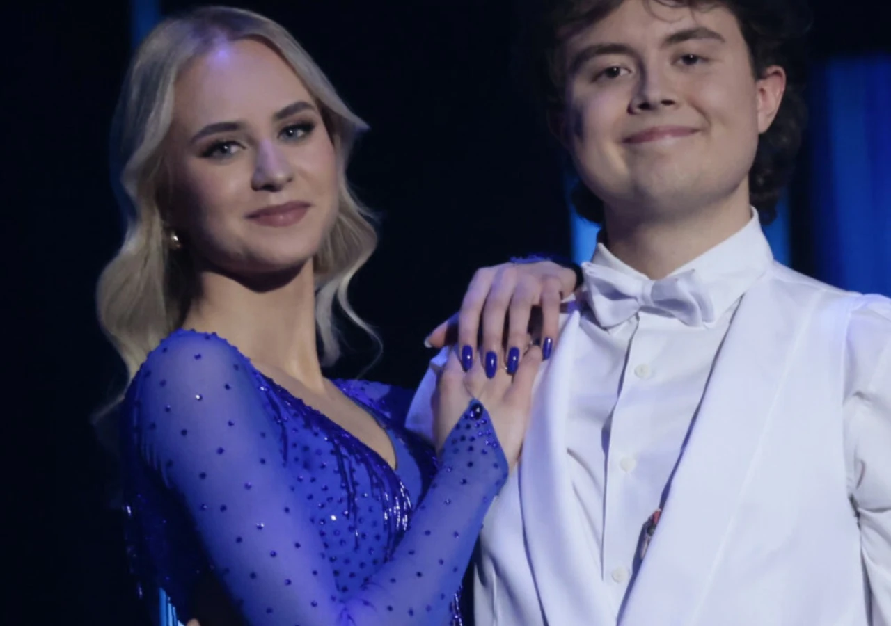 Mateusz Pawłowski i jego dziewczyna Kornelia Mateusz Pawłowski i Kornelia, ubrani elegancko, stoją blisko siebie i trzymają się za dłonie.