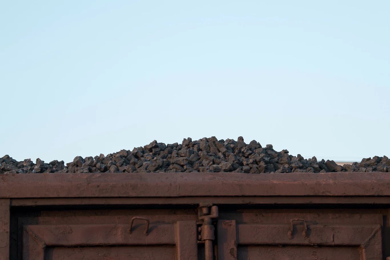 wagon kolejowy wypełniony czarnym węglem pod gołym niebem