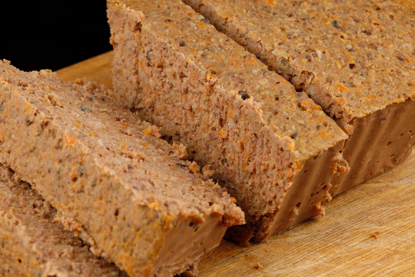 Ten pasztet to jeden z wielkanocnych hitów Pokrojony pasztet z królika na drewnianej desce.