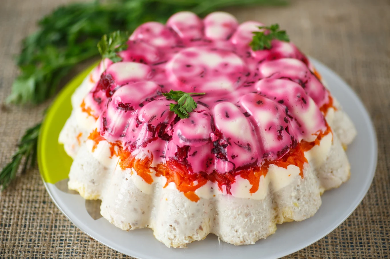 Takiej babki wielkanocnej jeszcze nigdy nie jadłeś. Robi się ją ze śledzi Wielkanocna babka śledziowa z burakami, jajkiem i warzywami podana na półmisku i udekorowana natką pietruszki