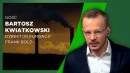 Bartosz Kwiatkowski w eleganckiej marynarce i białej koszuli, z zestawem słuchawkowym, na tle grafiki z dwiema kominami emitującymi ciemny dym oraz napisem informującym o jego funkcji dyrektora fundacji Frank Bold.