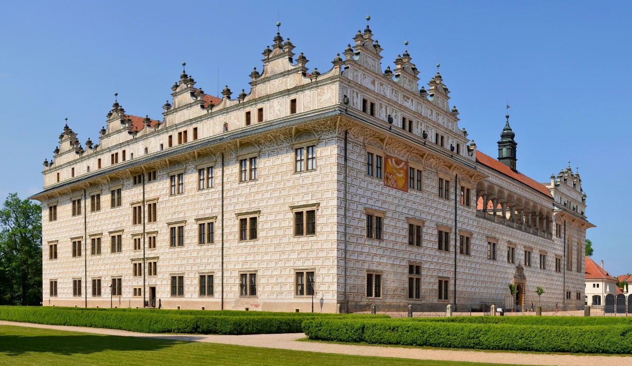 Litomyśl - zabytkowe miasteczko muzyki klasycznej Renesansowy pałac w Litomyślu z ozdobną fasadą, attyką i szczytami, otoczony trawnikami pod błękitnym niebem
