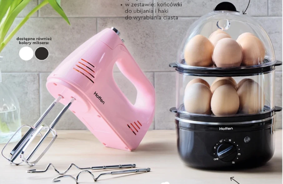 Różowy mikser ręczny marki Hoffen z metalowymi końcówkami do ubijania oraz parowar elektryczny tej samej marki z dwoma przezroczystymi poziomami, w których znajdują się jajka gotowane na parze.