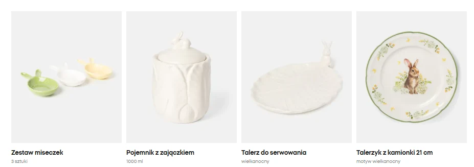 Komplet naczyń w delikatnych, pastelowych kolorach z motywem zajączków, w tym dwie miseczki w kształcie króliczych główek, biały pojemnik z przykrywką zakończoną figurką zająca, owalny talerz z dekoracyjnym uszkiem oraz ceramiczny talerz z ilustracją z...