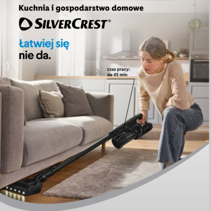 kobieta odkurzająca pod kanapą za pomocą bezprzewodowego odkurzacza SilverCrest z oświetleniem LED, nowoczesny i przytulny salon z szarą sofą oraz informacja o maksymalnym czasie pracy urządzenia do 45 minut