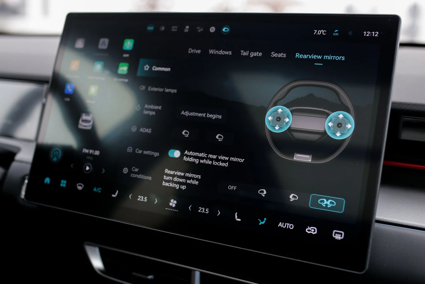 duży ekran dotykowy systemu multimedialnego samochodu z interfejsem do regulacji lusterek bocznych, wyświetlający szczegółowe opcje ustawień i temperaturę zewnętrzną