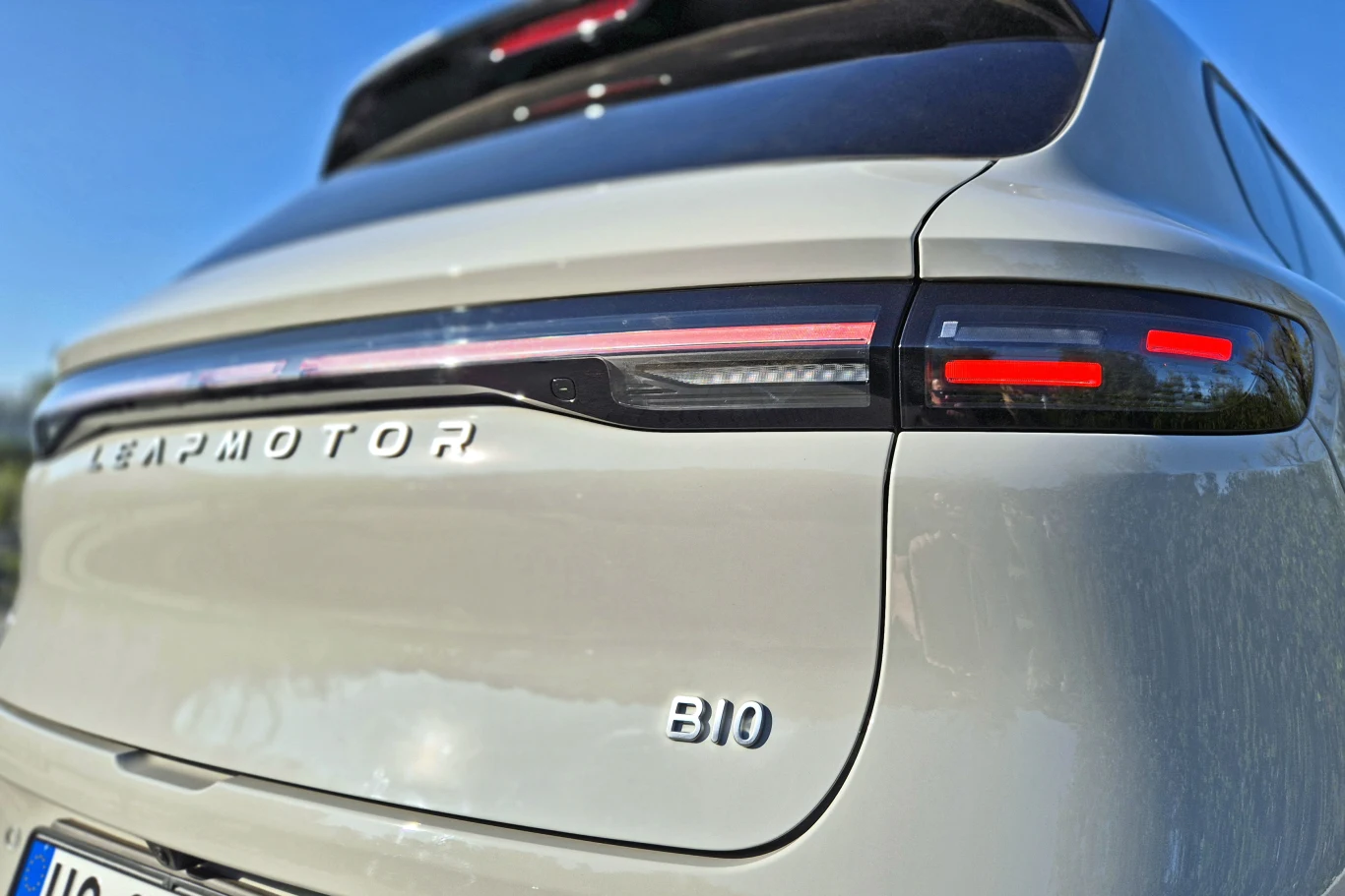 tylna część białego samochodu elektrycznego marki Leapmotor z modelu C10, z nowoczesnymi, poziomymi światłami LED oraz widocznym emblematem modelu i marki