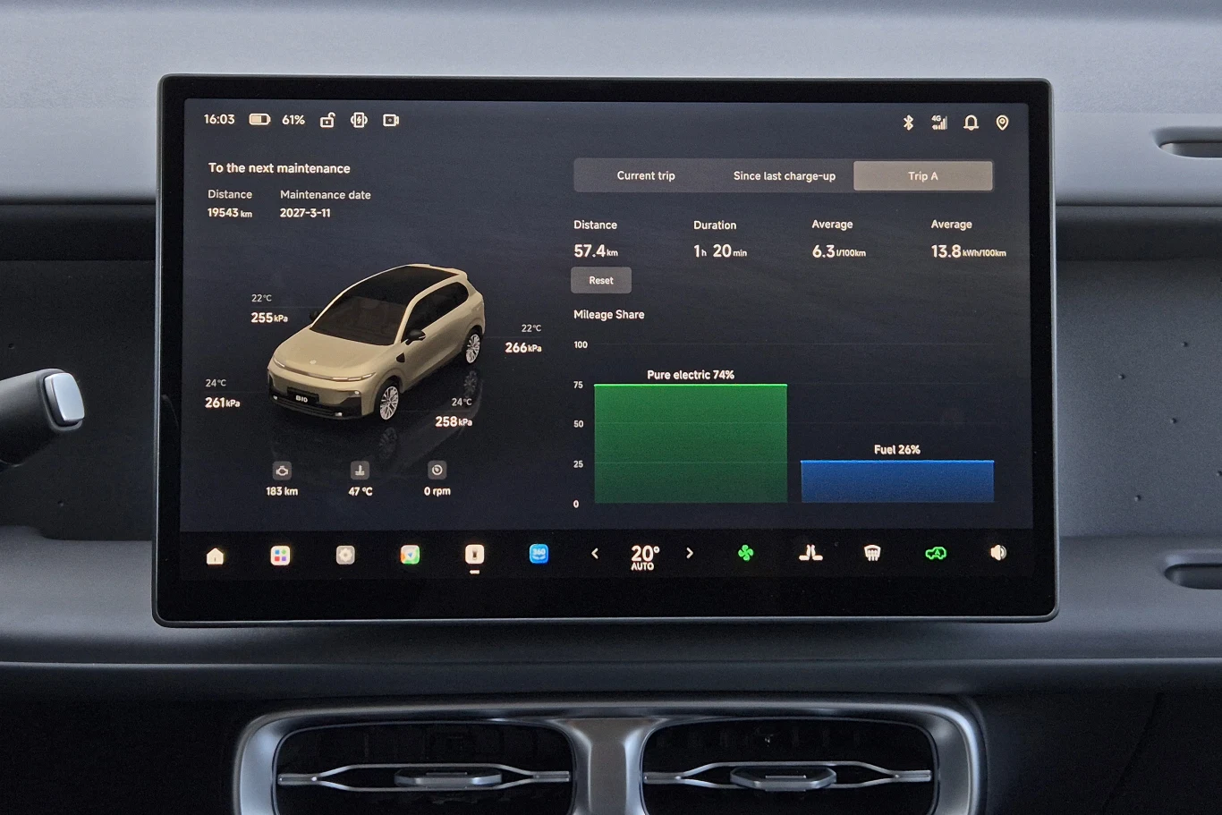 Ekran systemu multimedialnego samochodu wyświetlający szczegółowe informacje o stanie pojazdu, trybie napędu, zasięgu na energii elektrycznej i paliwie, statystykach zużycia oraz planowanym terminie konserwacji; centralnie widoczny model auta i wykresy...