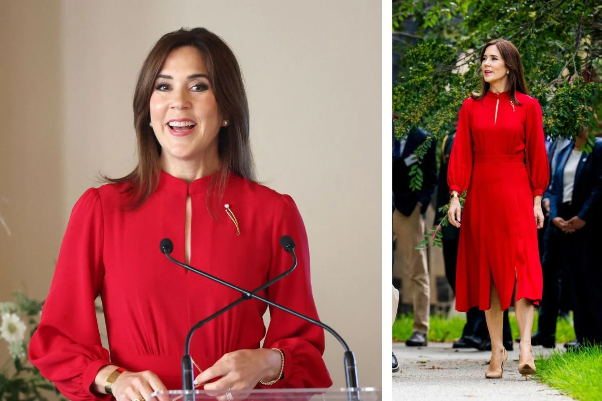 Kobieta w intensywnie czerwonej sukience z długimi rękawami i ozdobną broszką, podczas oficjalnego wystąpienia przy mikrofonie oraz spacerująca na zewnątrz, w otoczeniu ludzi; elegancka stylizacja dopełniają beżowe szpilki.