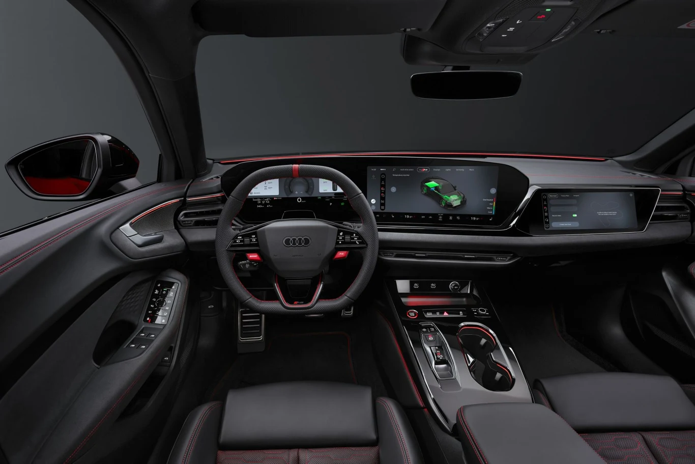 kokpit nowoczesnego samochodu Audi z cyfrowymi wyświetlaczami na desce rozdzielczej, sportową kierownicą i czerwonymi przeszyciami na tapicerce