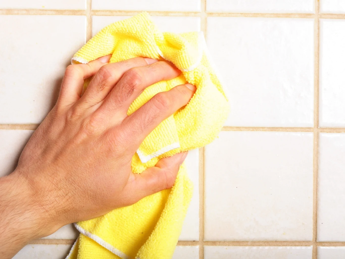 Czyszczenie płytek od dołu do góry jest bardziej wydajne i efektywne Wycieranie płytek łazienkowych ściereczką z mikrofibry.