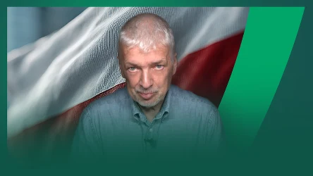 mężczyzna o siwych włosach i krótkiej brodzie patrzy prosto w obiektyw, w tle widoczna flaga Polski z charakterystycznymi białym i czerwonym pasem, całość otoczona graficznym, zielonym obramowaniem