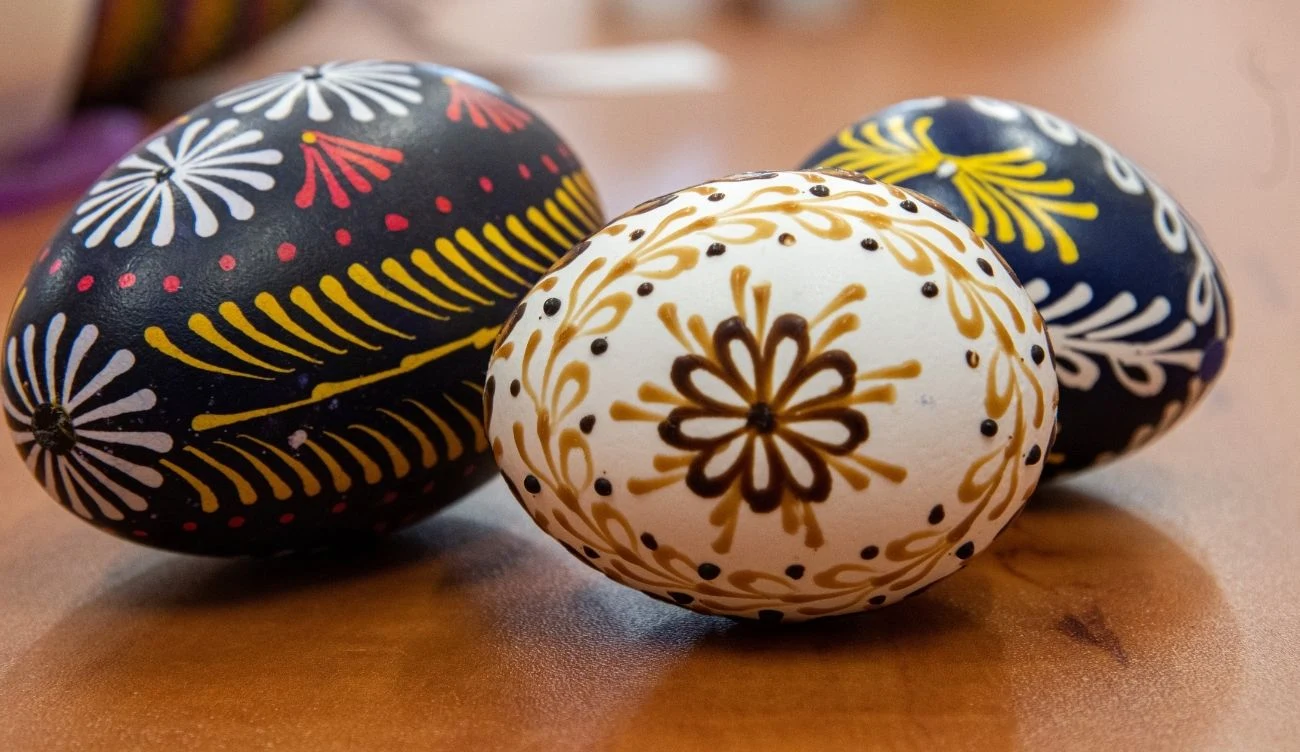 Tradycja zdobienia jajek sięga czasów przedchrześcijańskich Trzy pisanki z tradycyjnymi wzorami: biała z żółto-brązowym ornamentem, granatowa i czarna z geometrycznymi wzorami.