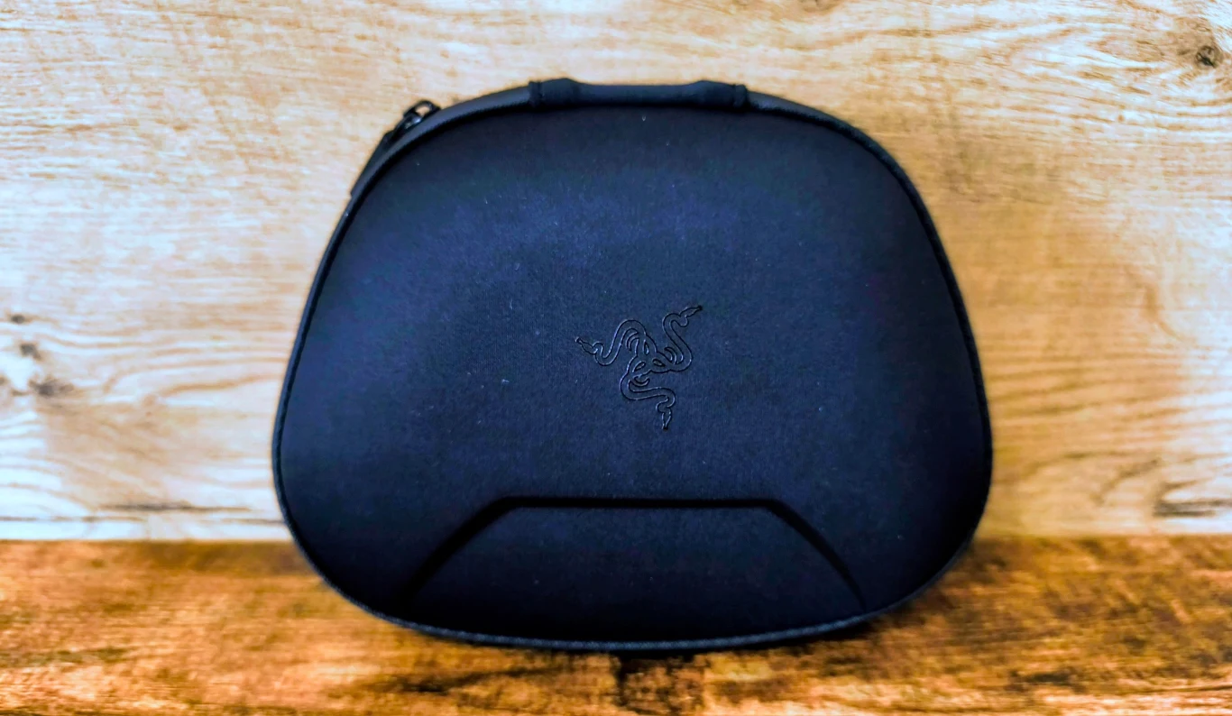 czarne etui z subtelnym logo marki Razer pośrodku, ustawione na drewnianej powierzchni na tle jasnej, drewnianej ściany
