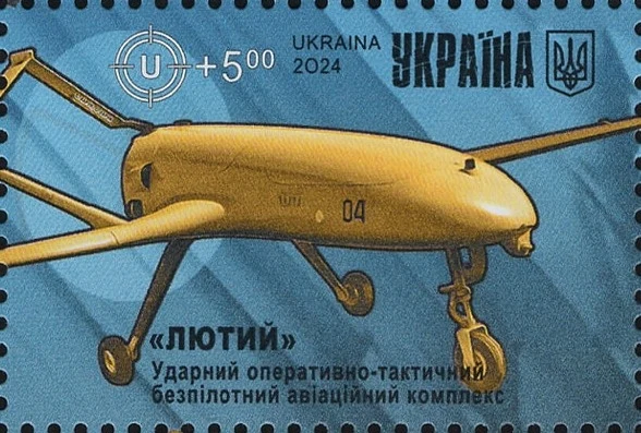 dron bojowy w barwach pustynnych z rozłożonymi skrzydłami, widoczny z przodu i z góry, na tle niebieskiego cienia, z napisem po ukraińsku, godłem Ukrainy i oznaczeniem wartości znaczka 5 UAH; całość utrzymana w graficznym stylu charakterystycznym dla z...