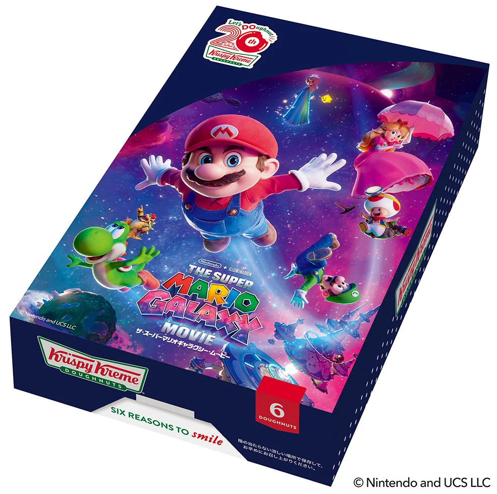 Kolorowe opakowanie z postaciami z gry Super Mario Galaxy, w tym Mario, Peach, Yoshi oraz inne znane postacie na tle kosmicznego pejzażu; na dole widoczne logo Krispy Kreme i informacja o sześciu donutach wewnątrz.
