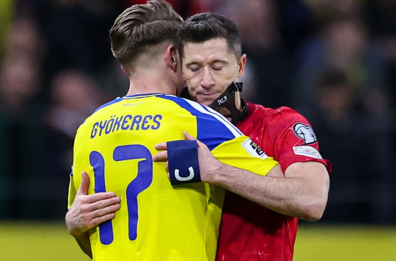 dwóch piłkarzy obejmuje się na boisku, zawodnik w żółtej koszulce z numerem 17 i nazwiskiem Gyökeres na plecach oraz piłkarz w czerwonym stroju z opaską kapitana na ramieniu