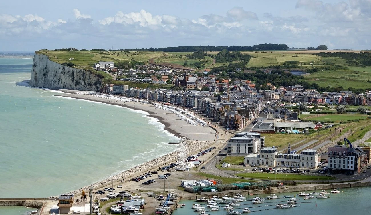 Mers-les-Bains przyciąga coraz większą uwagę turystów Mers-les-Bains: długa plaża, białe klify, budynki i hotele przy brzegu, port jachtowy, droga nadmorska