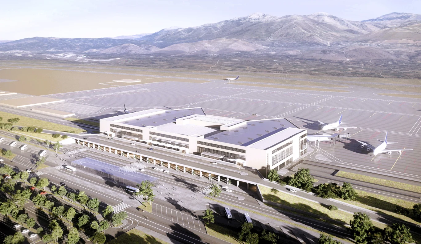 Na Krecie rośnie nowe lotnisko. Najnowsze nagranie pokazuje postępy z prac przy ogromnej inwestycji. Nowoczesny terminal lotniska New Heraklion na Krecie, stojące samoloty, góry i drogi z drzewami w tle.