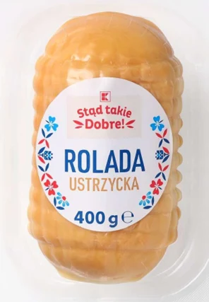 opakowana rolada ustrzycka o wadze 400 g z jasną, żółtą skórką i białą etykietą z napisem „Stąd takie Dobre!” oraz elementami dekoracyjnymi w formie niebieskich i czerwonych kwiatuszków