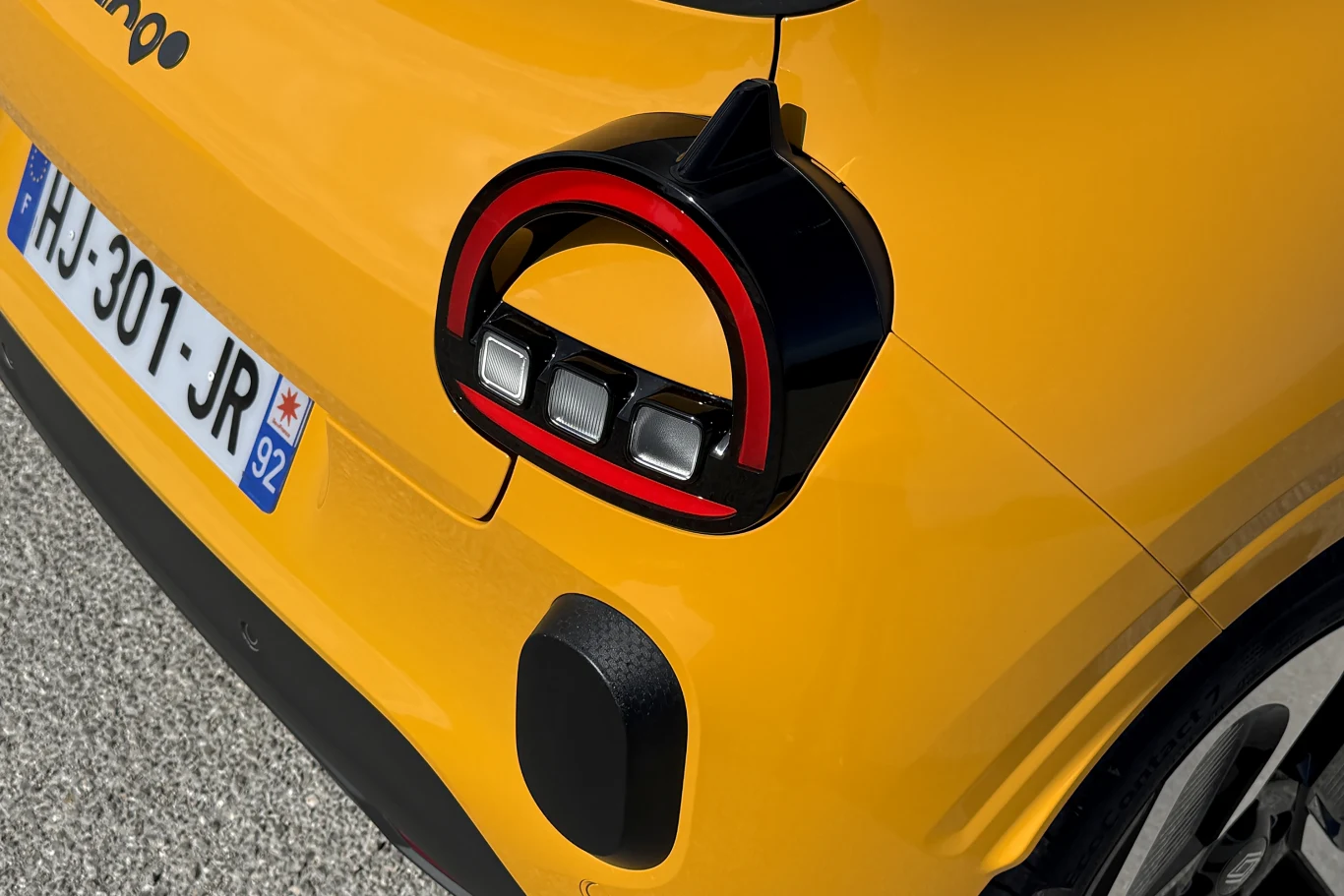 żółty samochód z nowoczesnym, zaokrąglonym tylnym światłem w kształcie litery C, detal tylnej części auta, widoczna francuska tablica rejestracyjna