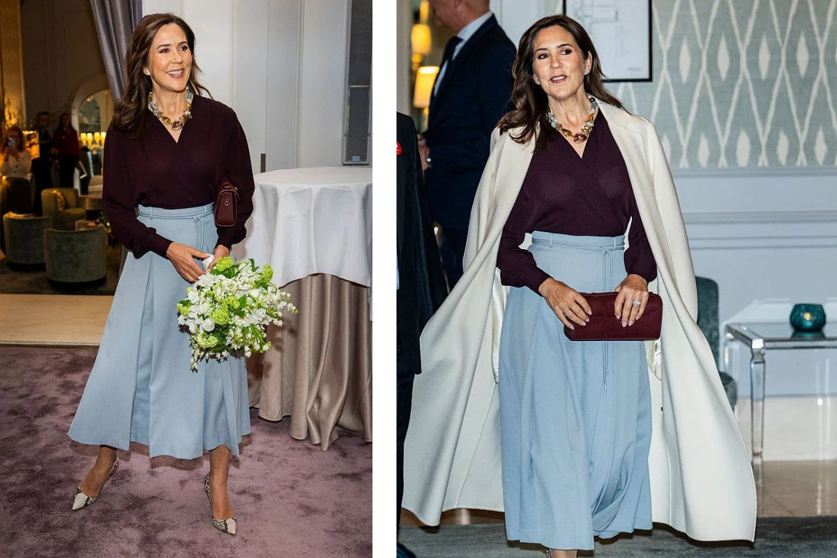 Elegancka kobieta ubrana w bordową bluzkę i błękitną spódnicę midi trzyma w ręku bordową kopertówkę oraz bukiet białych kwiatów; na jednym ze zdjęć ma narzucony jasny płaszcz, a całość stylizacji dopełniają delikatne szpilki i wyrazista biżuteria.