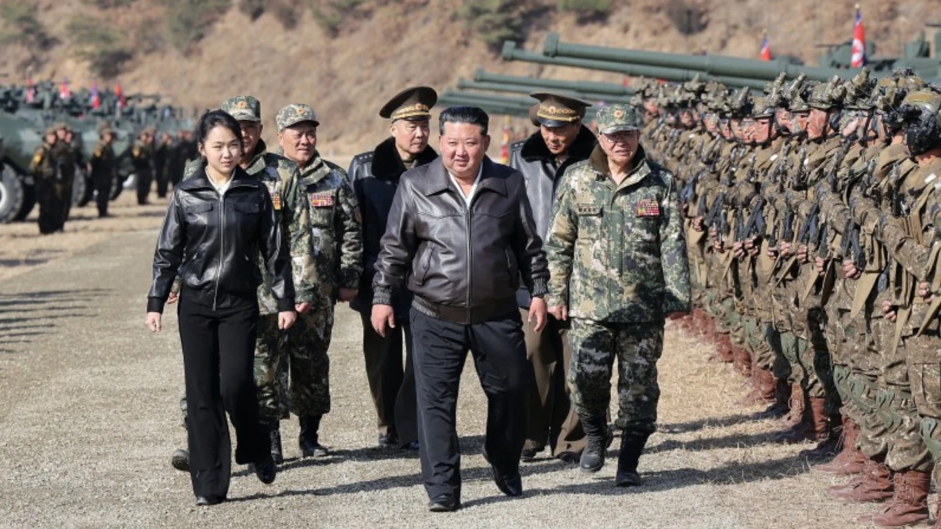 Kim Dzong Un z ciemnej skórzanej kurtce w towarzystwie córki i wojskowych maszeruje wzdłuż szeregu żołnierzy. Zdj. ilustracyjne