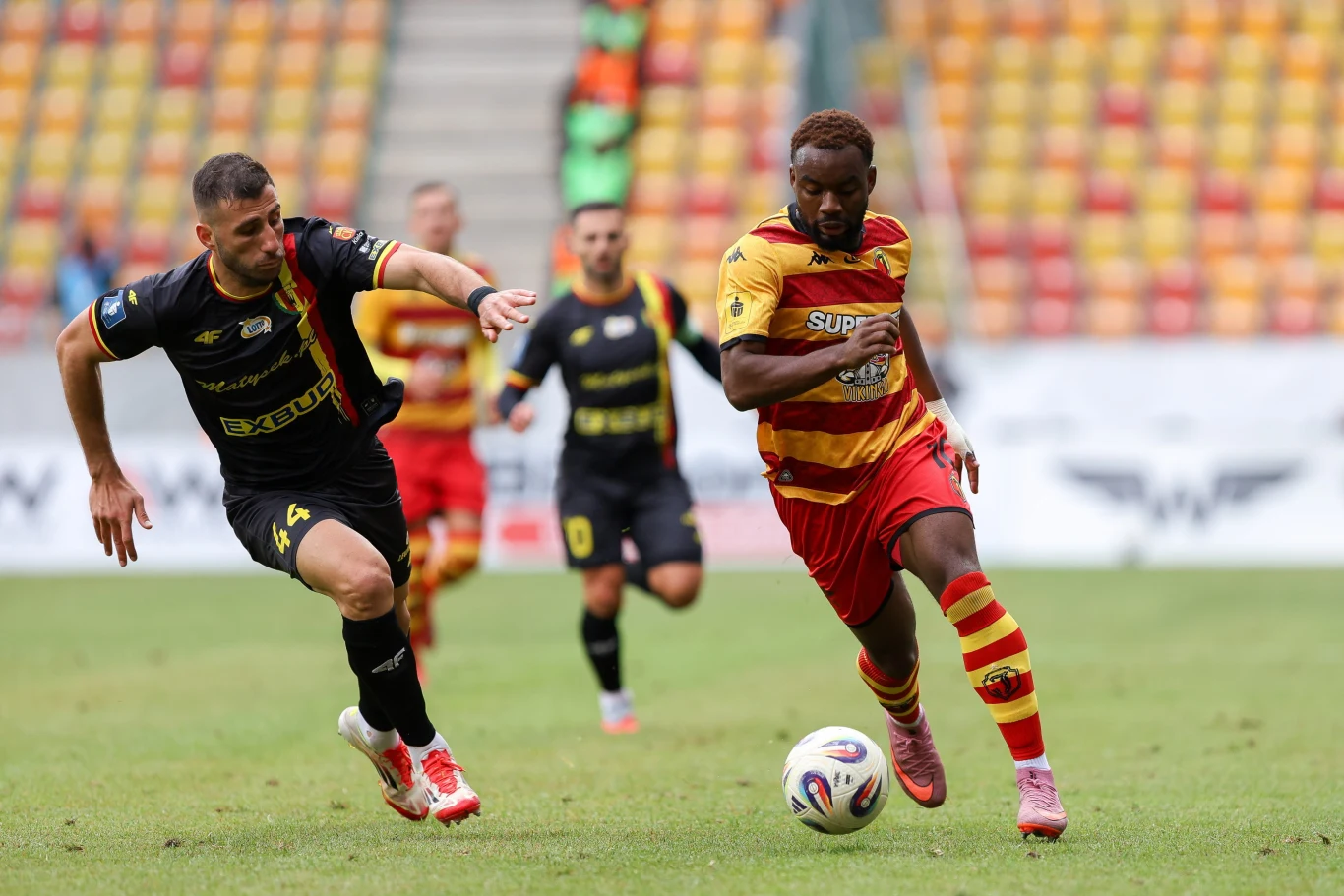 Konstantinos Sotiriou i Afimico Pululu w meczu PKO BP Ekstraklasy Jagiellonia - Korona Konstantinos Sotiriou i Afimico Pululu walczą o piłkę podczas meczu Jagiellonia - Korona na stadionie Ekstraklasy