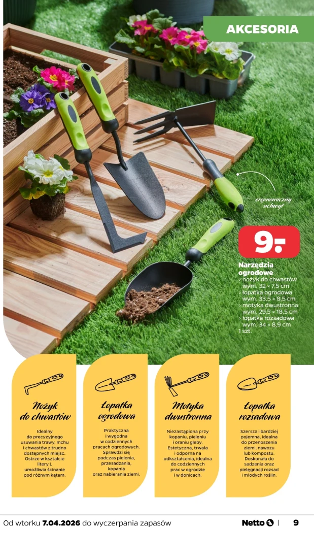 Komplet narzędzi ogrodowych z zielono-czarnymi uchwytami, składający się z łopatki, motyki i widełek, ułożony na drewnianej skrzynce w otoczeniu kwiatów w doniczkach i skrzynkach na tle sztucznej trawy.