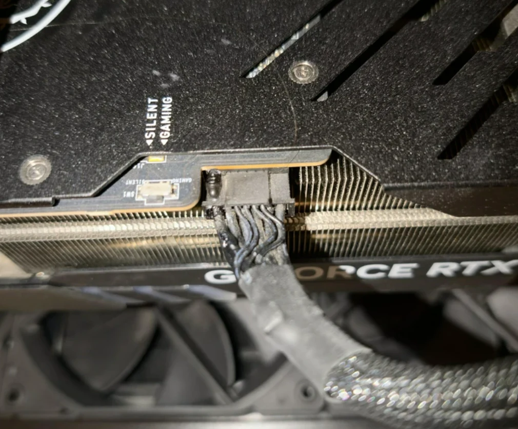 przewód zasilający karty graficznej GeForce RTX z wyraźnie przypalonym i stopionym złączem, wskazującym na poważną awarię lub przegrzanie komponentu