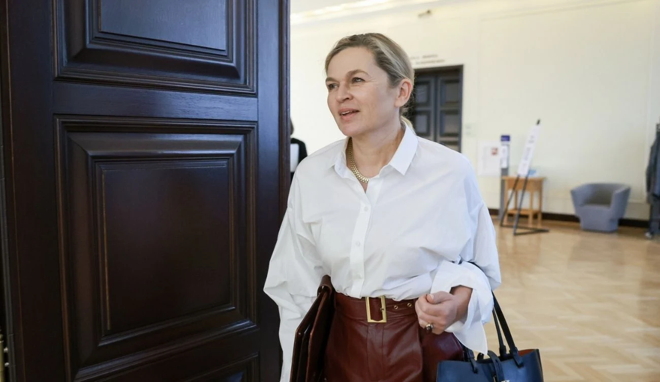 Edukacja zdrowotna będzie obowiązkowa od września 2026 roku Barbara Nowacka w białej koszuli i bordowej skórzanej spódnicy z torebką wychodzi z jasnego pomieszczenia.