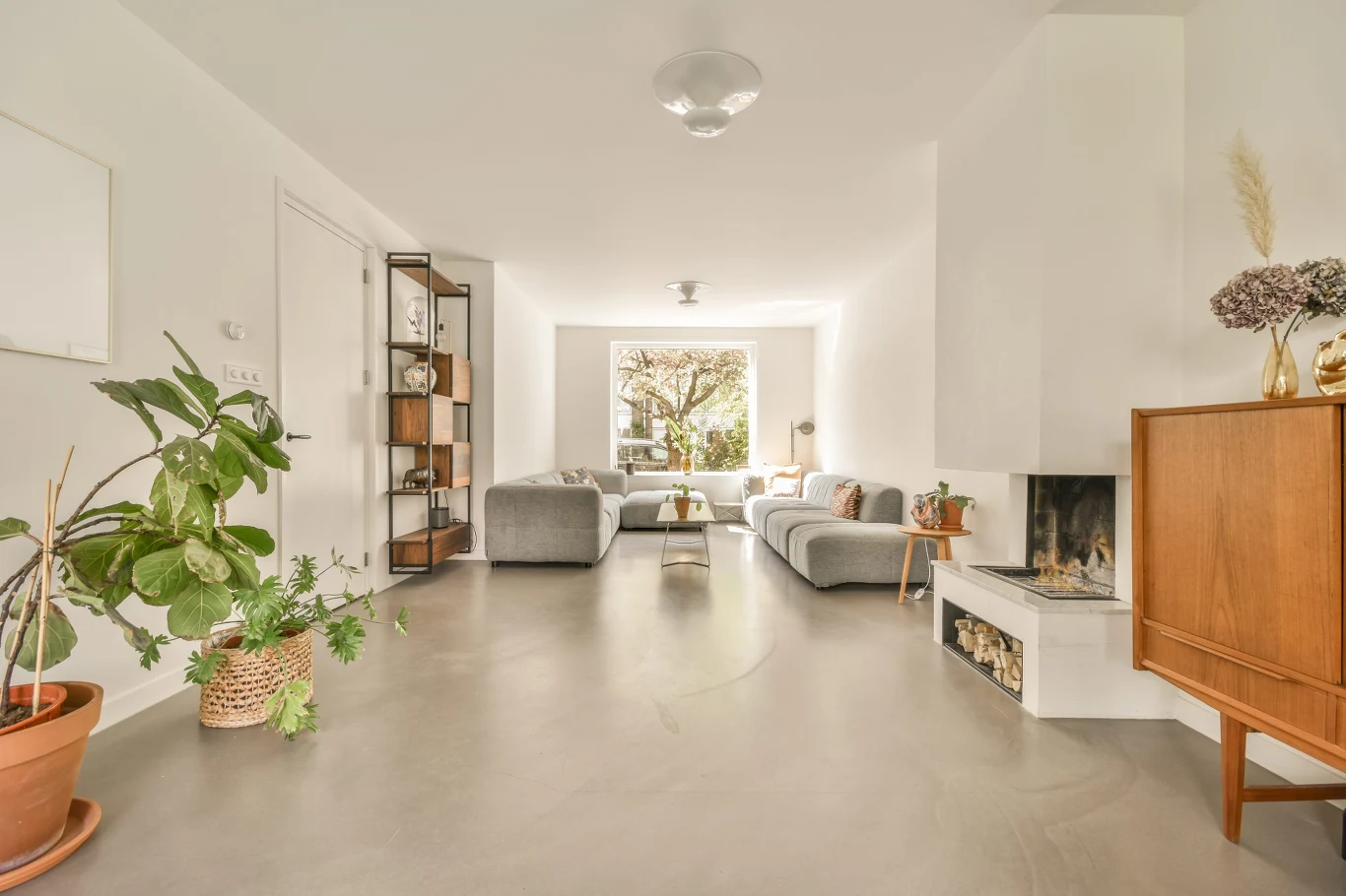 Płytki i panele są już passe. Coraz więcej osób stawia na podłogę bez fug i łączeń. Jasny salon z podłogą bez fug i łączeń. Nowoczesna aranżacja salonu z wykorzystaniem posadzki poliuretanowej.