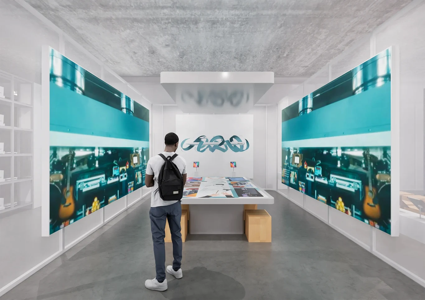 W Muzeum Apple w Ultrechcie na odwiedzających czekają liczne wystawy i atrakcje. osoba z plecakiem stoi w nowoczesnej galerii, zwrócona w stronę stołu z wystawionymi materiałami, otoczona dwoma dużymi ekranami lub obrazami z motywem maszyn w odcieniach niebieskiego, wnętrze minimalistyczne i jasne