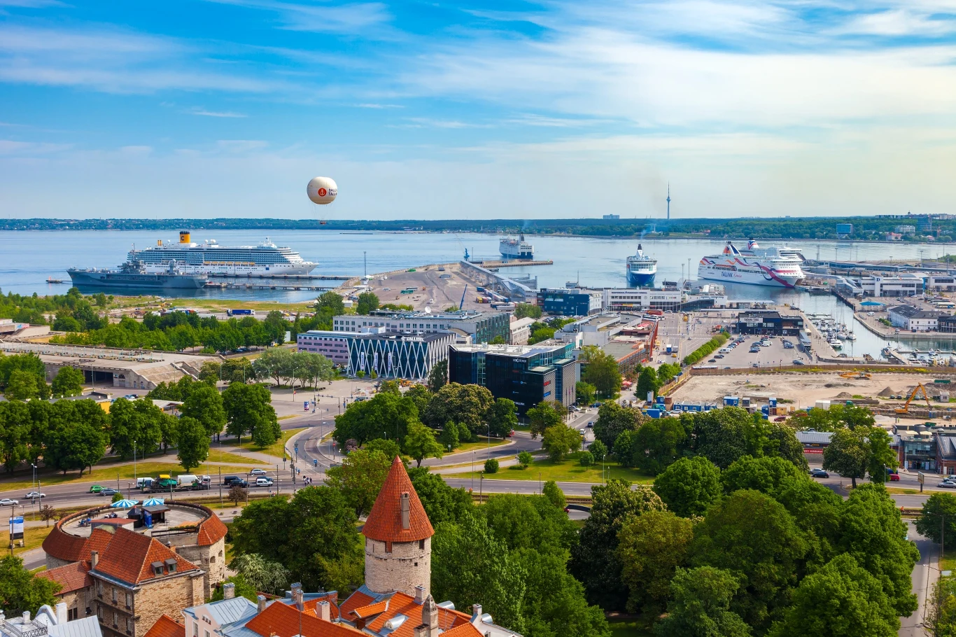 Tallin to wyjątkowo bezpieczne miasto. Stolicę Estonii można zwiedzać także tunelami podziemnymi panorama portu z dużymi statkami wycieczkowymi zacumowanymi przy nabrzeżu, otoczona zielenią i nowoczesnymi budynkami, w tle spokojna tafla wody, nad którą unoszą się chmury, a w powietrzu widoczny balon obserwacyjny