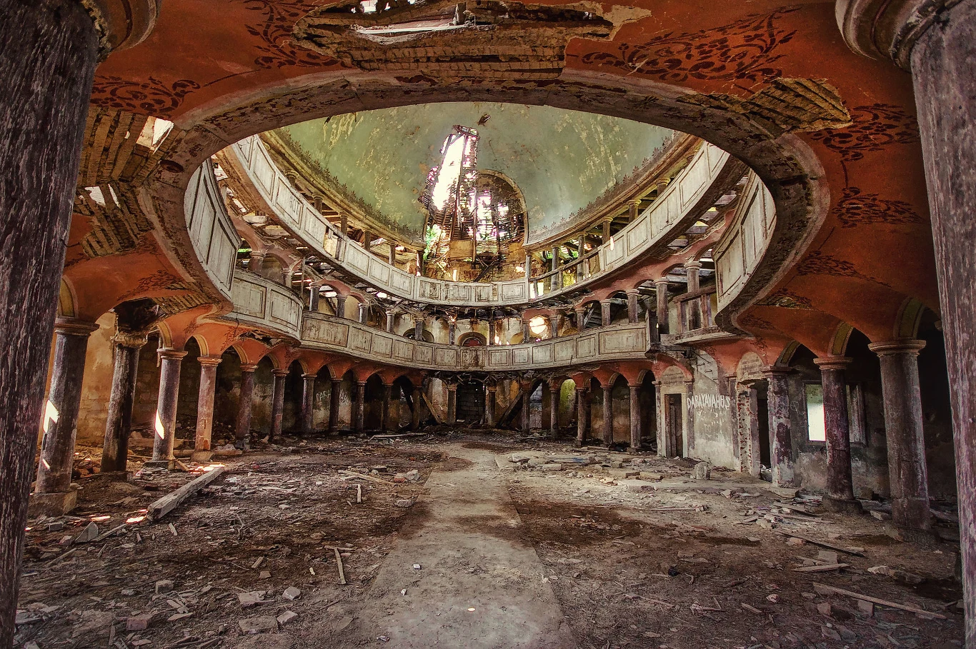 Fotografowie pokochali to miejsce Opuszczone, zniszczone wnętrze kościoła z dwupoziomową galerią, wysokimi kolumnami i zrujnowaną kopułą, przez którą wpada światło, podkreślając zaawansowane ślady upływu czasu i gruzu na podłodze.