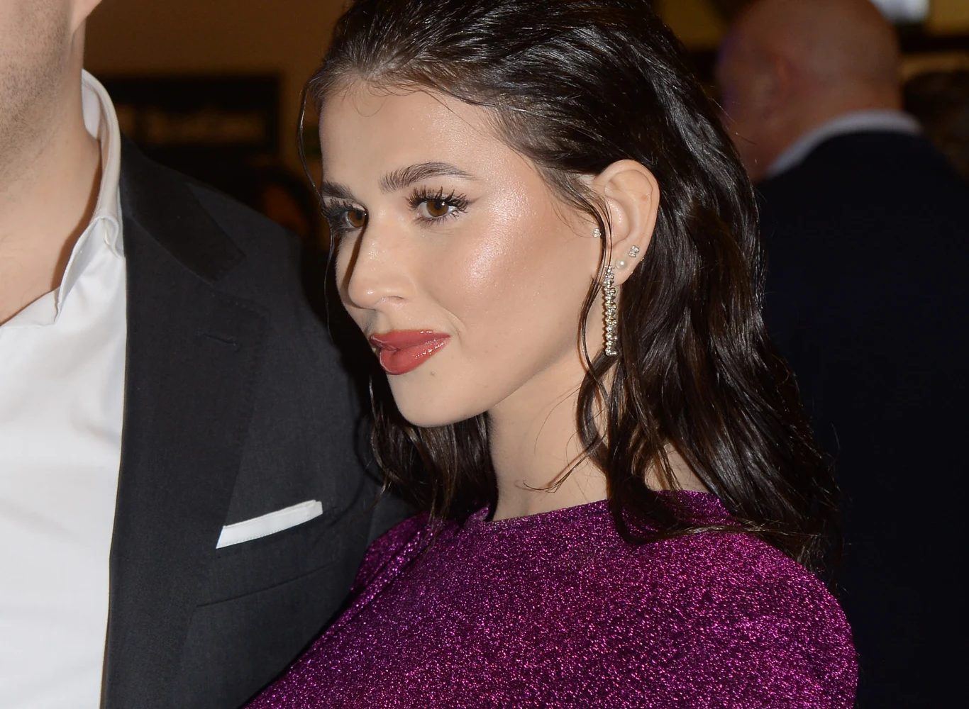 Roksana Węgiel Roksana Węgiel w fioletowej, błyszczącej sukience z długimi kolczykami obok mężczyzny w czarnym garniturze