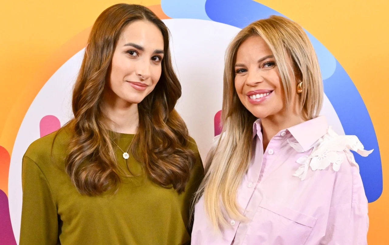 Paula Frączek-Hanc, Paulina Biernat Paula Frączek-Hanc i Paulina Biernat stoją obok siebie na tle kolorowej grafiki.