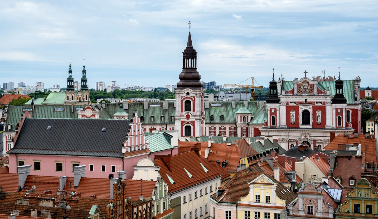 W jakich miastach w Polsce żyje się najlepiej? Panorama Starego Miasta z wieżą kościoła, czerwonymi dachami i barokowym budynkiem z kolumnadą w Polsce
