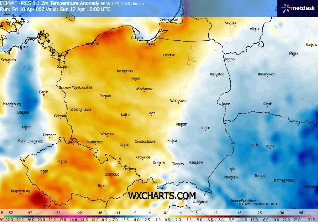 Mapa anomalii temperatury pokazująca znaczne ocieplenie w zachodniej i centralnej Polsce zaznaczone odcieniami pomarańczowo-czerwonymi, podczas gdy wschodnia część kraju dominuje w chłodniejszych, niebieskich barwach, z czytelnie zaznaczonymi nazwami n...
