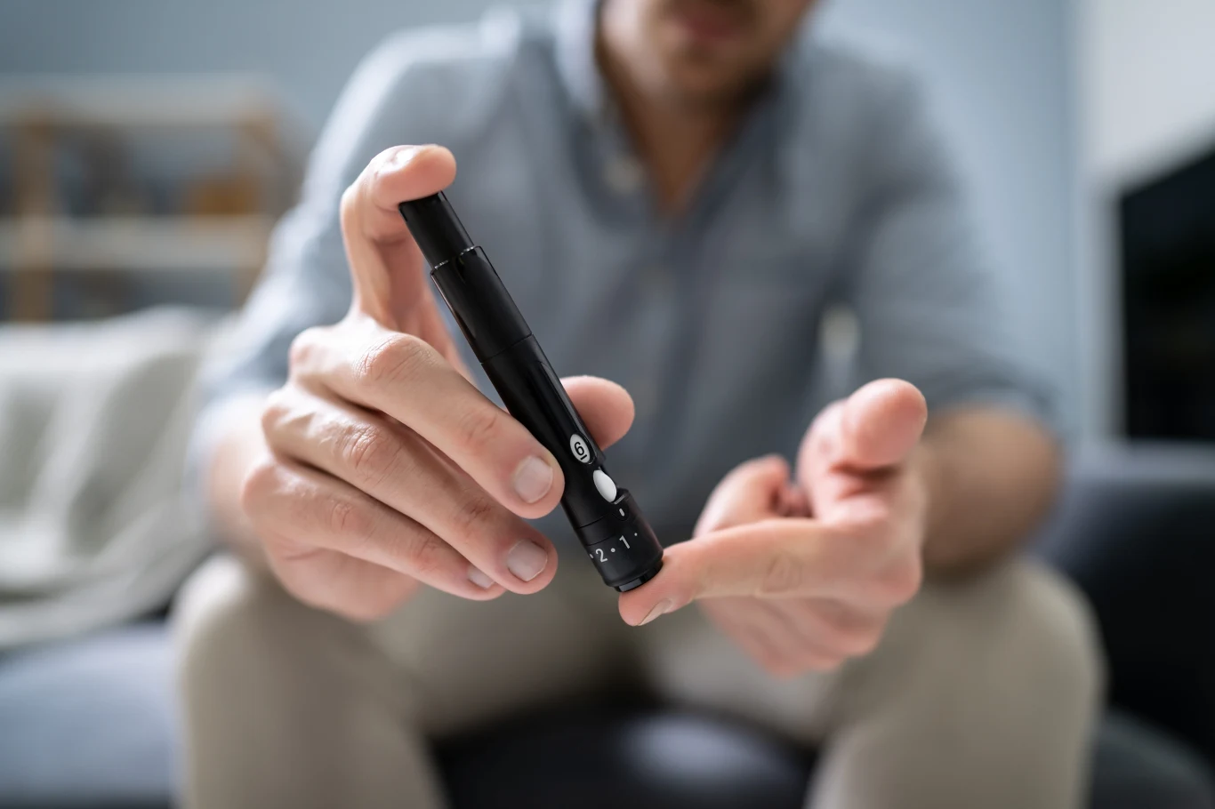 Grupa krwi a zdrowie metaboliczne. Jedno powiązanie okazało się kluczowe Mężczyzna mierzy poziom cukru we krwi glukometrem, trzyma lancet przy palcu, grupa krwi a metabolizm