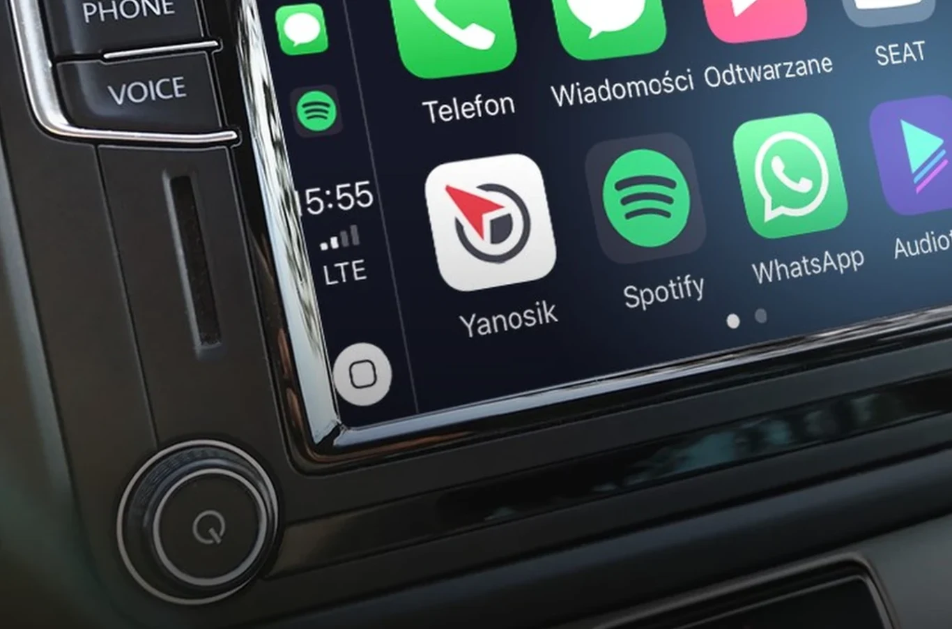 Aktualizacja WhatsApp dla Apple CarPlay - co się zmieniło w samochodzie? Ekran Apple CarPlay w samochodzie z widocznymi ikonami Yanosik, Telefon, Spotify i WhatsApp oraz panelem sterowania.