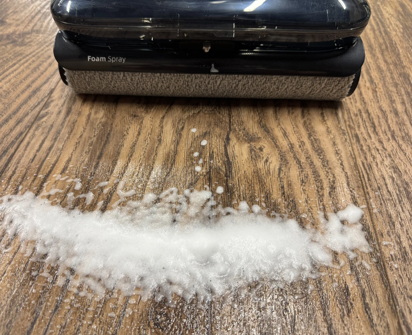 F25 Ace Pro posiada certyfikat TUV, co oznacza, że jest produktem przyjaznym zwierzętom wałek czyszczący z napisem 'Foam Spray' rozprowadza pianę na drewnianej powierzchni, skupiając uwagę na procesie czyszczenia