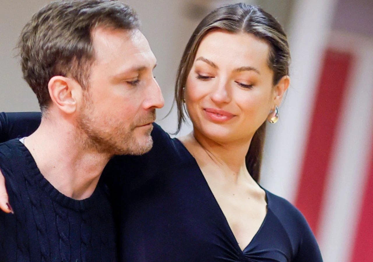 Kamil Nożyński, Izabela Skierska Kamil Nożyński i Izabela Skierska obejmują się, on patrzy w bok, ona się uśmiecha, elegancko ubrani, rozmyte tło