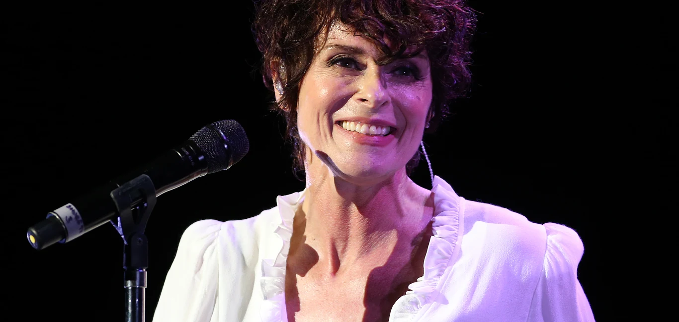Lisa Stansfield w 2019 roku Lisa Stansfield w 2019 roku na scenie, w białej bluzce z falbanami, przy mikrofonie