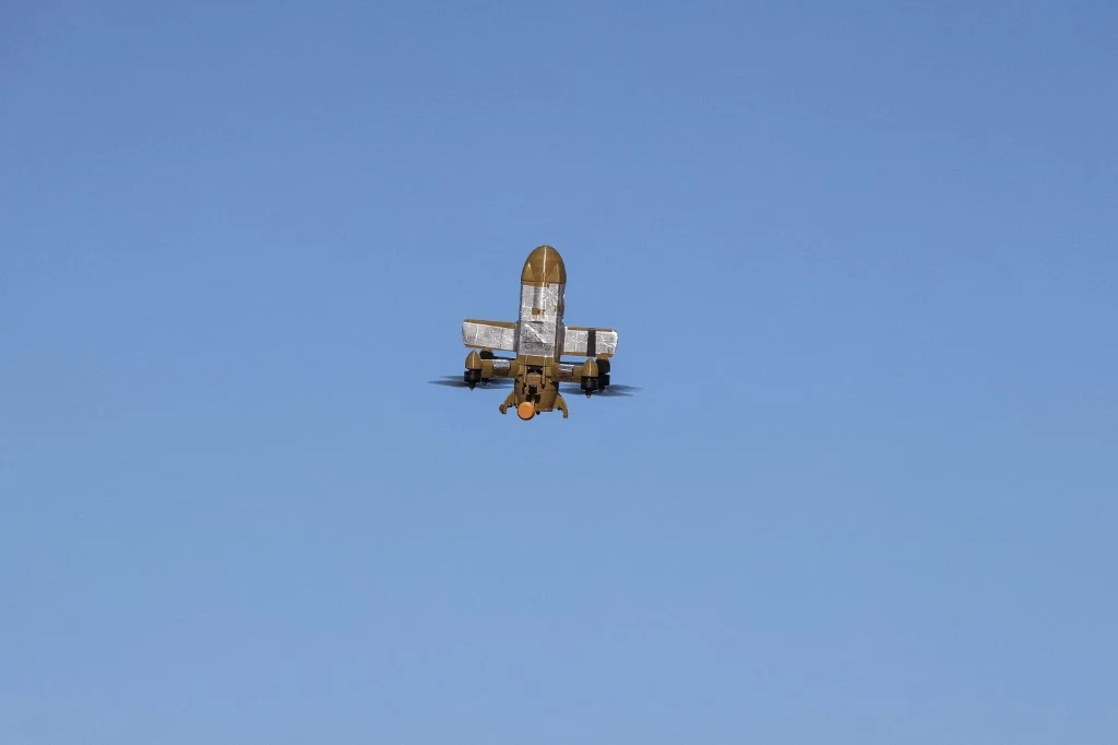 Ukraiński dron (zdj. ilustracyjne) Samolot rolniczy w locie na tle bezchmurnego, niebieskiego nieba, widoczny od tyłu z rozłożonymi skrzydłami.