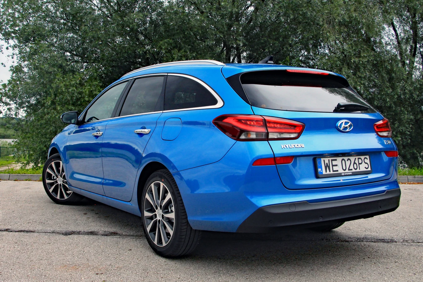 Hyundai i30 kombi niebieski samochód kombi marki Hyundai z polskimi tablicami rejestracyjnymi, stojący na utwardzonej powierzchni na tle zielonych drzew